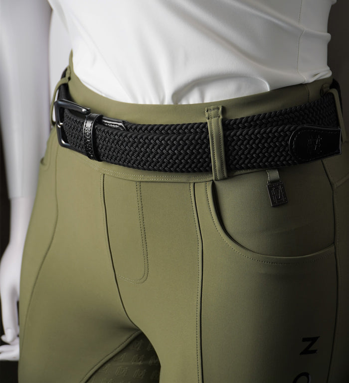 Green riding pants with a black belt on a mannequin