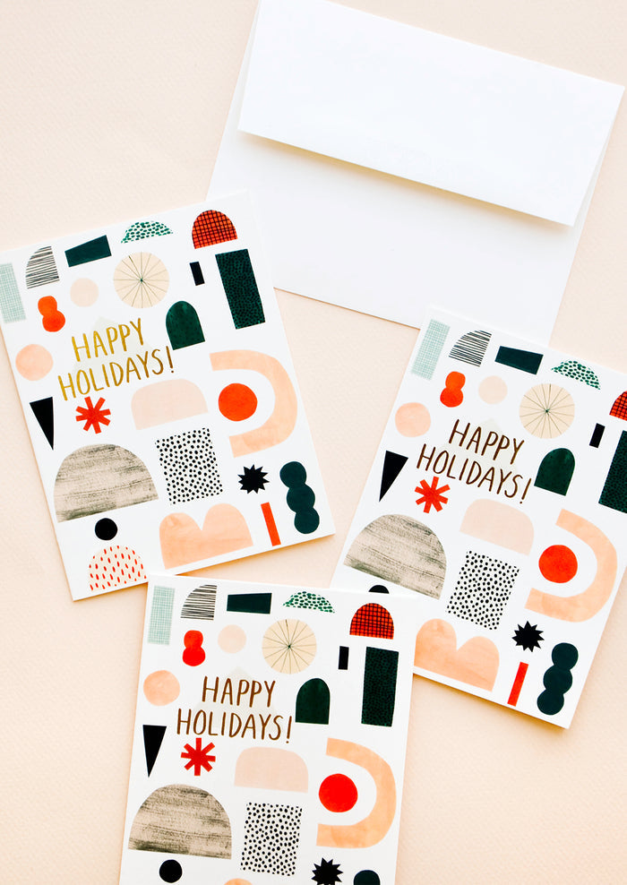 Three greeting cards with illustrated shapes and "Happy Holidays" written in gold foil.