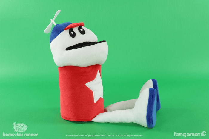 The Homestar Runner puppet plush against a green background, seated with its legs splayed out.