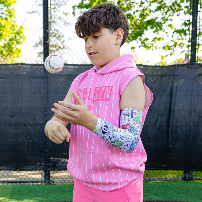 Youth player tossing a baseball wearing the white Jackson Olson x BL101 illustrated arm sleeve