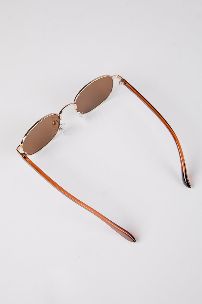Sunglasses with brown gradient lenses on a light gray background