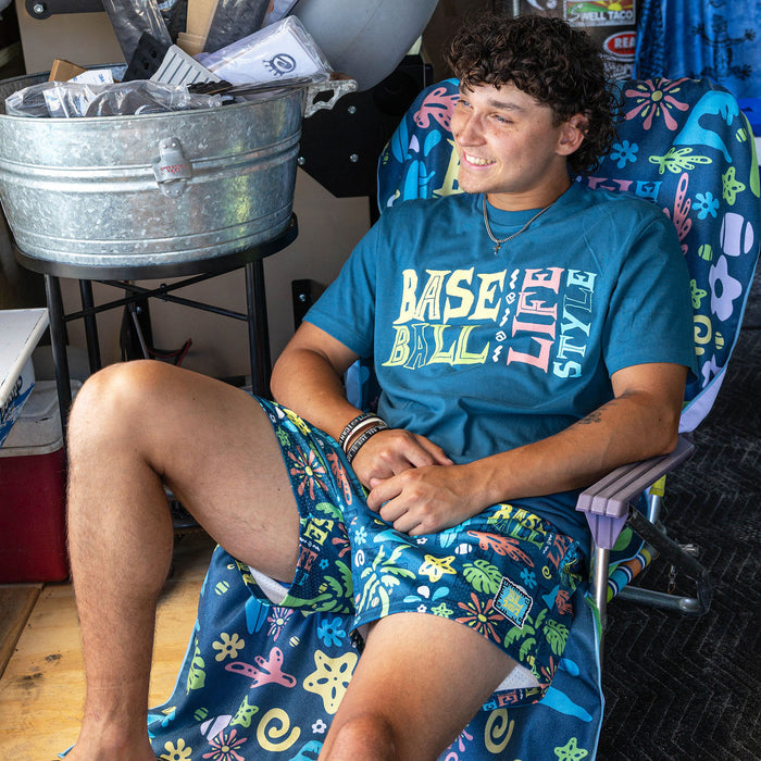 Adult model wearing blue graphic tee with "Surfside Slugger" design