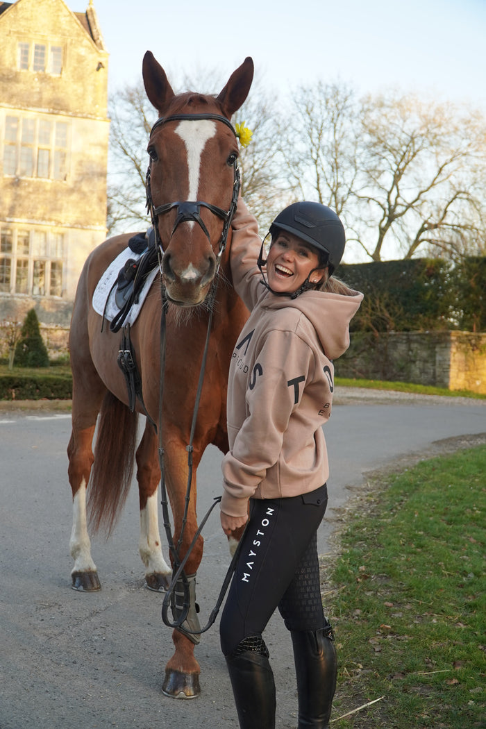 Person in equestrian attire with two horses on a path. Brown beige and black hoodie
High quality luxurious 100% cotton. wrap around bold logo. soft, cozy and warm. Hoodie, jumper sweatshirt. everyday wear. casual and smart