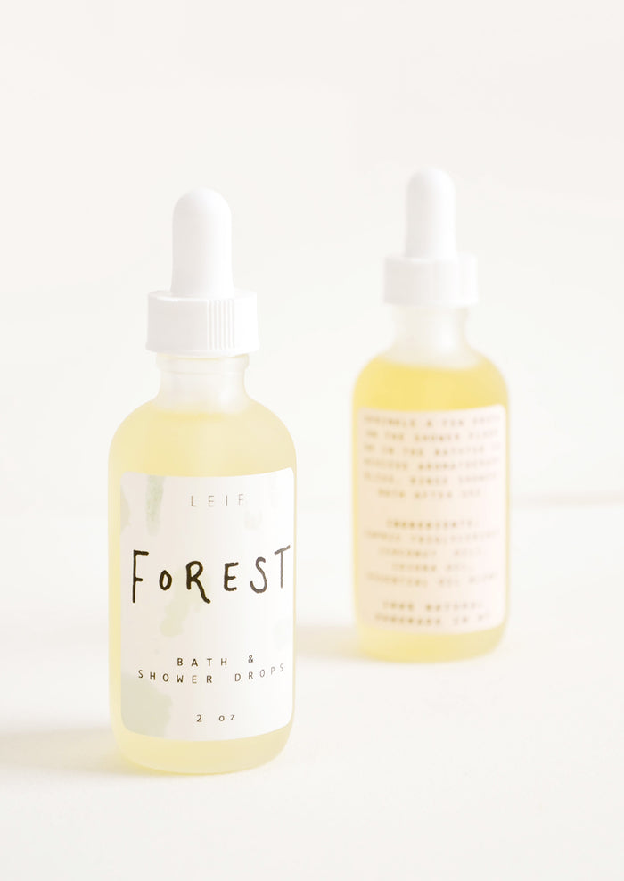 Two frosted glass dropper bottles with white lids and labels.