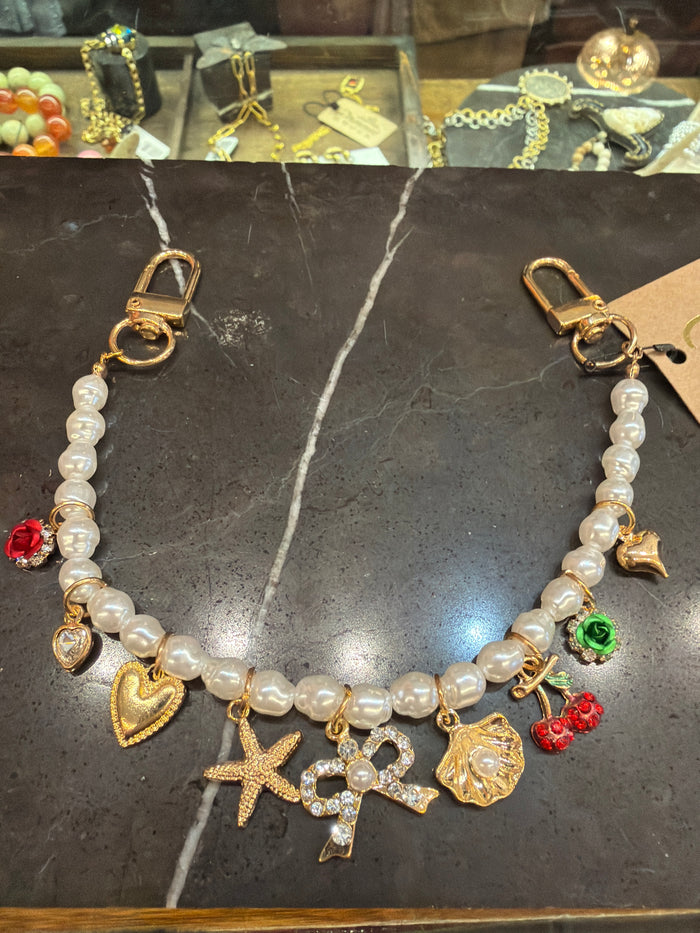Joia bag chain charm attached to a handbag, showcasing a stylish accessory for enhancing purse decor.