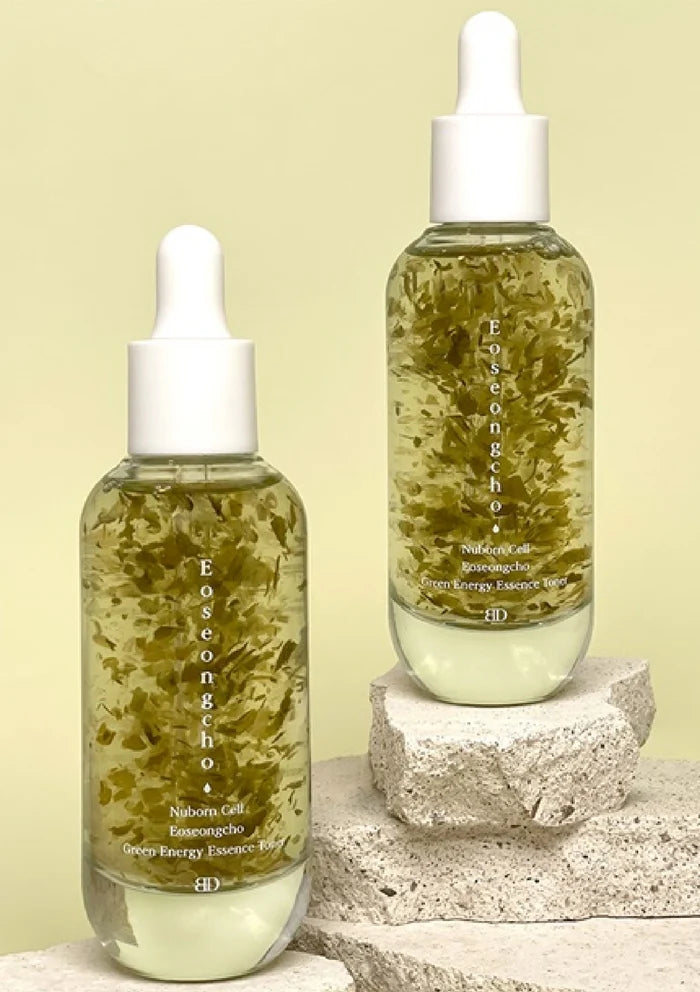 Two bottles of Eoseongcho skincare product on a stone surface with a light green background