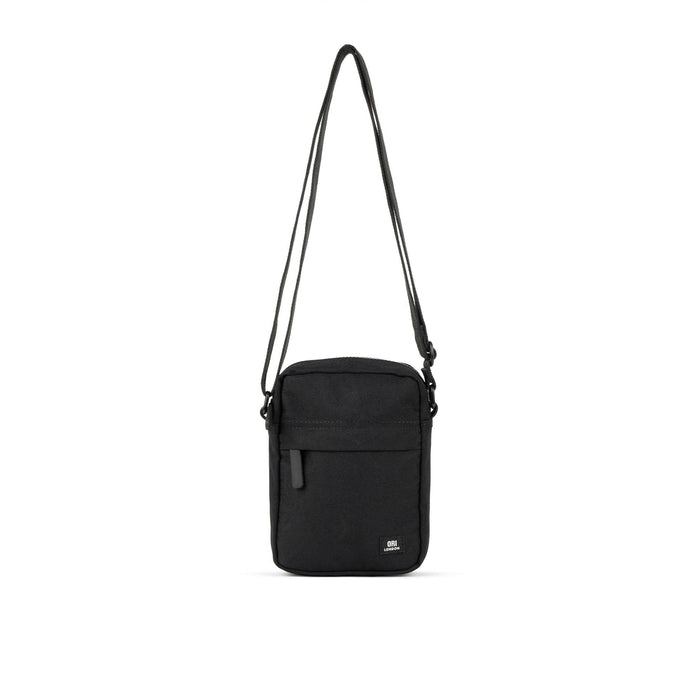 Recycled canvas crossbody bag in all-black with front flap and adjustable strap