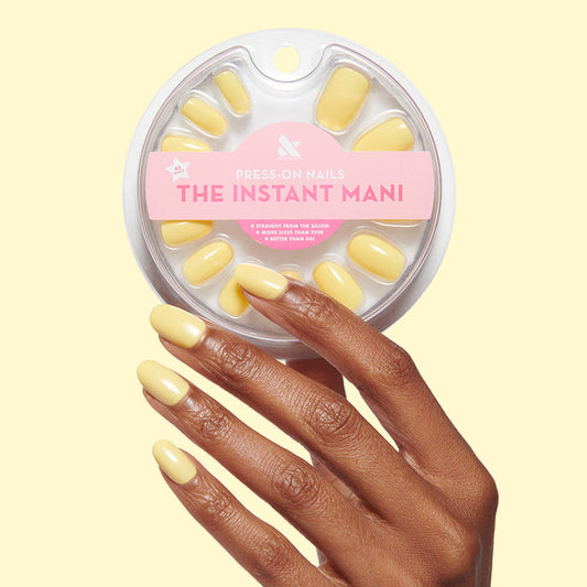 Bright & Focused | Round | Short bright yellow short round press-on nails shown on hand with package on pale yellow background