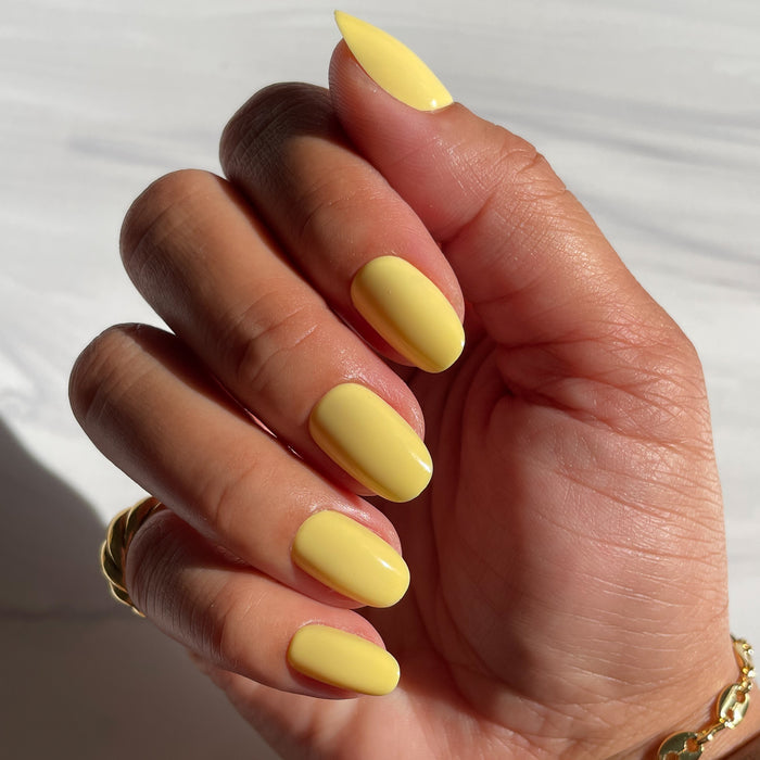 Bright & Focused | Round | Short yellow press-on nails in short round shape with a smooth matte finish shown on hand in natural light