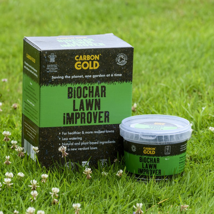 A package and a tub of Carbon Gold Biochar Lawn Improver placed on a grassy surface.