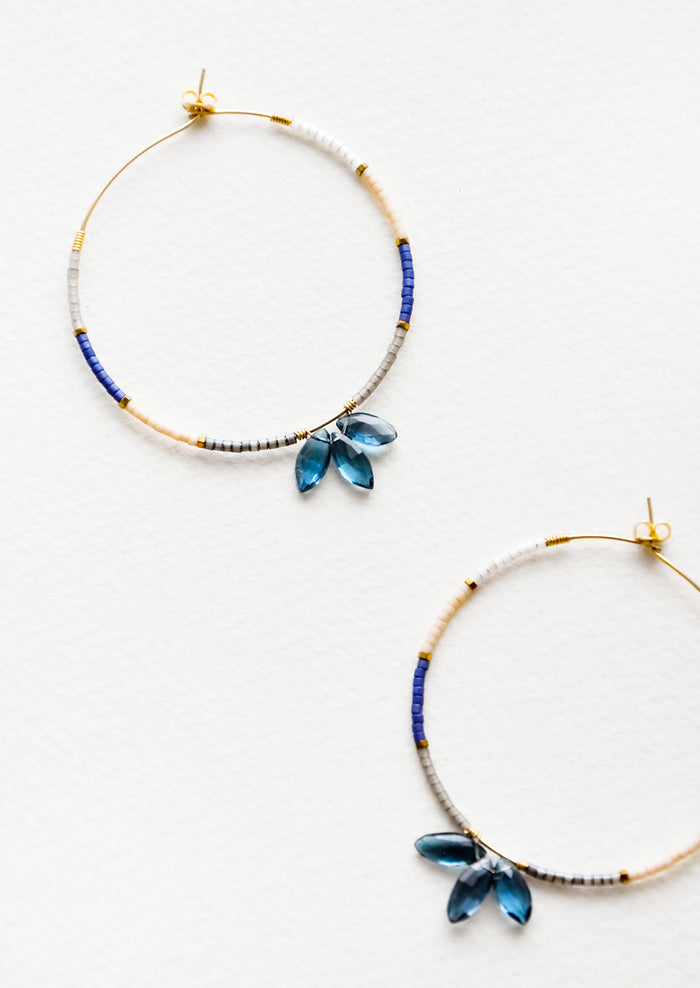 Delicate hoop earrings of blue and pink glass beads featuring a trio of larger blue beads at bottom center.