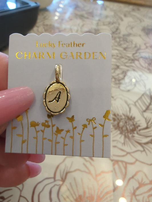 Gold initial charm with the letter A from Lucky Feather's Charm Garden collection, featuring intricate design on a silver charm.