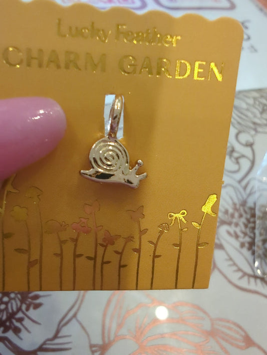 Gold snail charm from Lucky Feather's Charm Garden collection, featuring a detailed snail design on a small decorative charm.