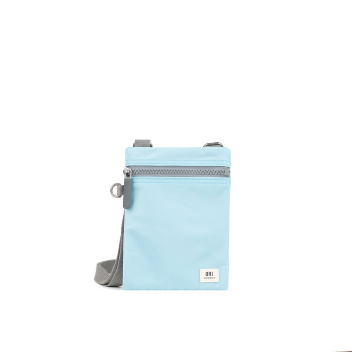Light blue recycled nylon pocket crossbody bag with zip top and adjustable strap