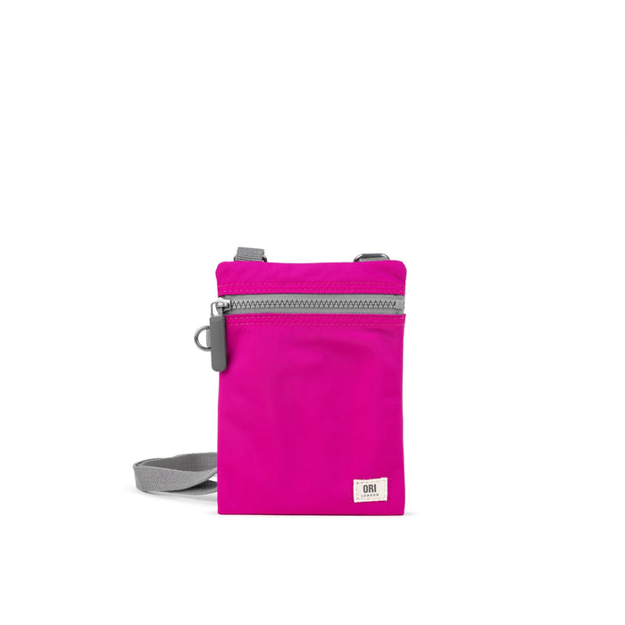 Hot pink recycled nylon pocket crossbody bag with zip top and gray adjustable strap