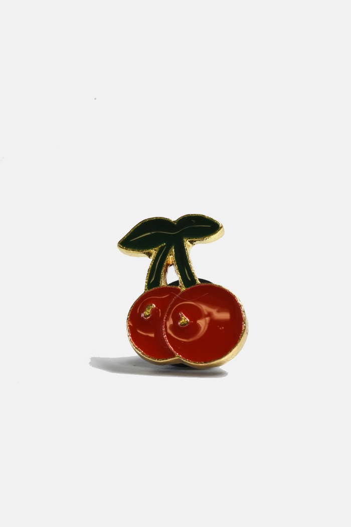 Cherry-shaped pin from Curated Basics, featuring a vibrant red cherry design with green leaves on a metal pin back.