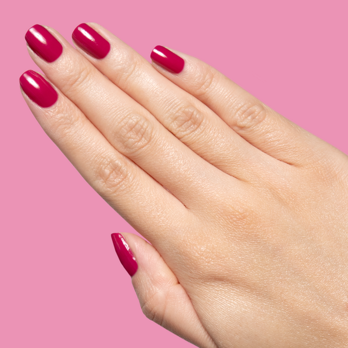 Hand showcasing glossy Darling gel polish in bold hot magenta on natural nails with smooth quick dry manicure