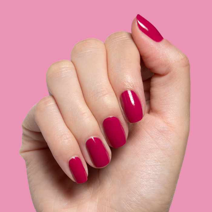 Hand displaying quick dry Darling gel polish in striking hot magenta on natural nails with smooth manicure