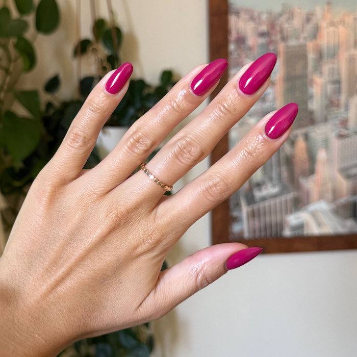 Hand with natural nails painted in vibrant Darling hot magenta gel polish showing glossy quick dry manicure