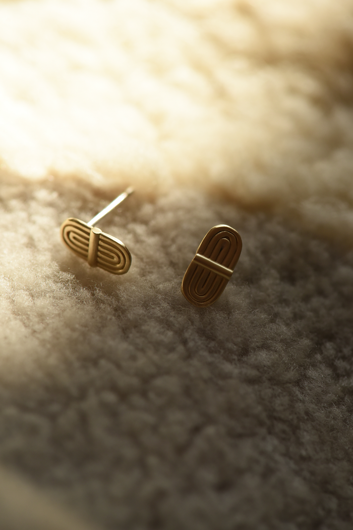 Pair of gold-tone double-arc brass stud earrings with curved bar fronts