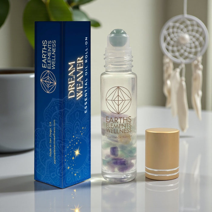 Earth's Elements Wellness Dream Weaver essential oil roll-on with packaging on a reflective surface.