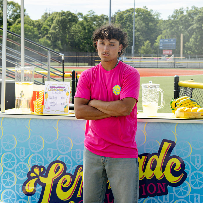 Adult model wearing pink graphic tee with "Electric Lemonade" design