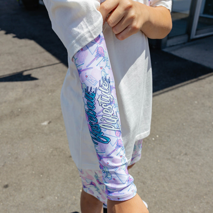 Youth model wearing youth sleeve with "Fastball Scoops Arm Sleeve" design