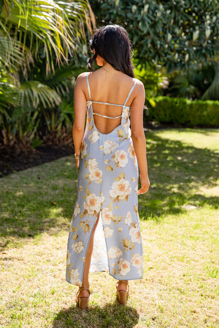 Woman in a floral dress standing in a garden