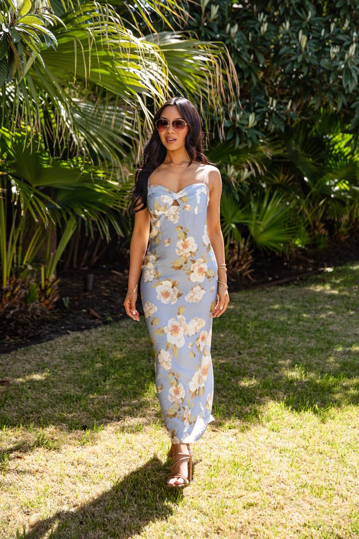 Woman in a floral dress standing in a garden