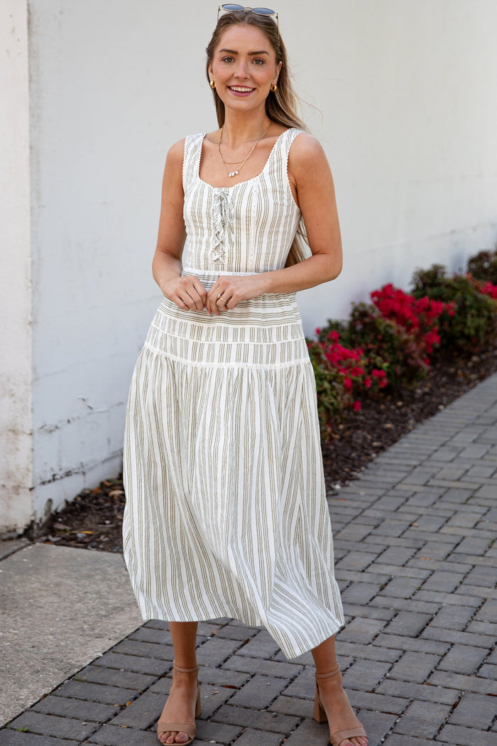 Woman wearing a spring striped maxi dress with sunglasses and nude heels