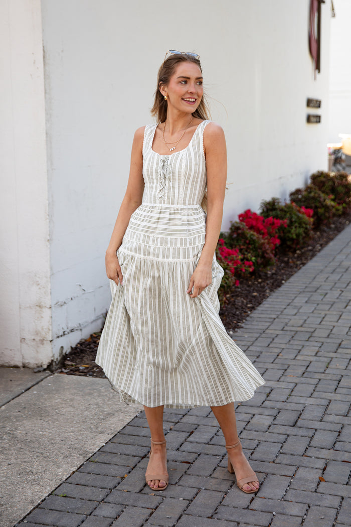Woman wearing a spring striped maxi dress with sunglasses and nude heels
