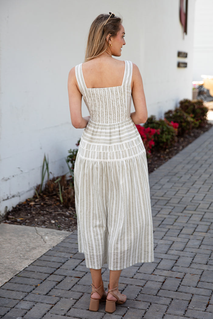 Woman wearing a spring striped maxi dress with sunglasses and nude heels