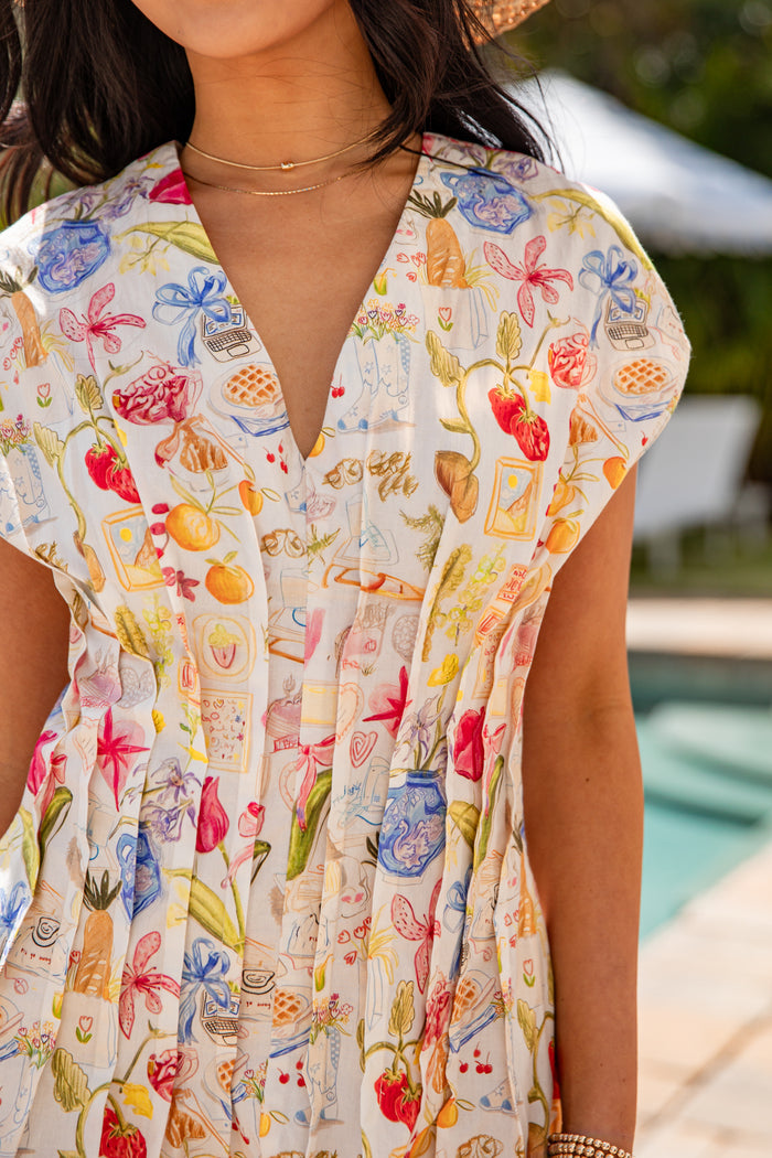 Woman wearing a colorful floral dress by a poolside