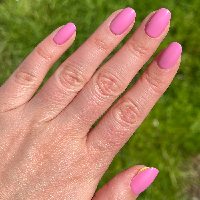 Hand with Grateful & Kind | Round | Short pure pink press-on nails in a short round shape for easy at-home mani