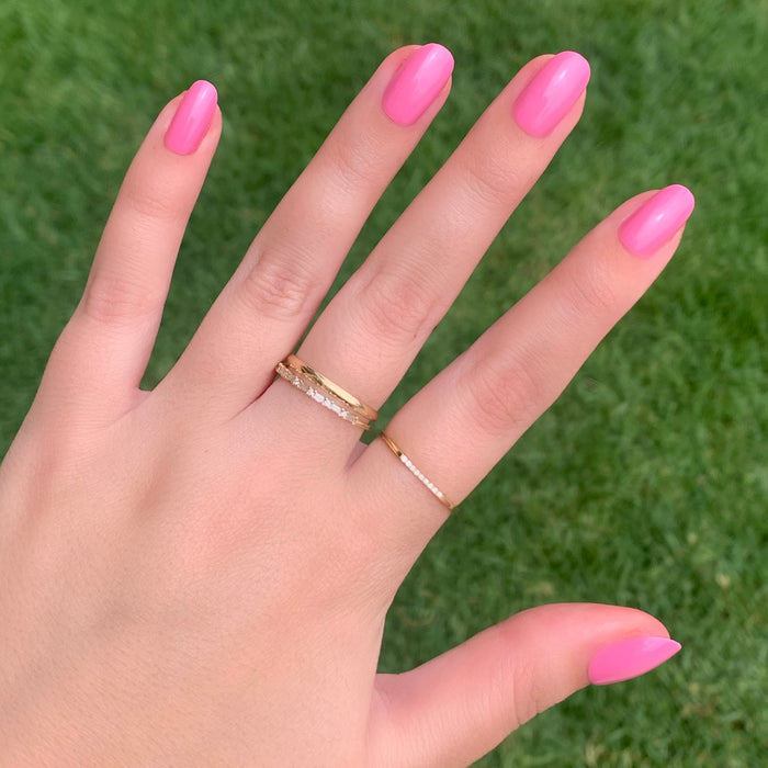 Hand with Grateful & Kind | Round | Short pink press-on nails in short round shape wearing gold rings outdoors