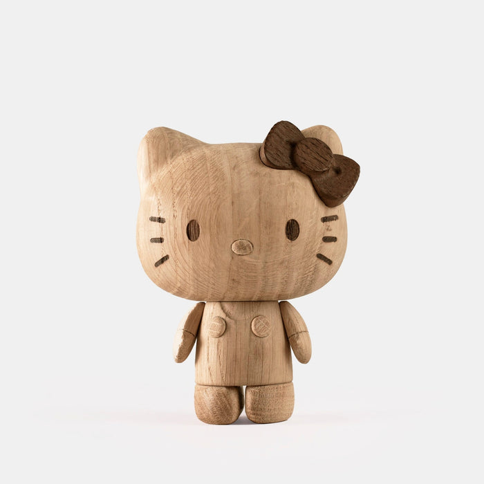 Hello Kitty wooden figurine with bow, angled side view, carved face and paws