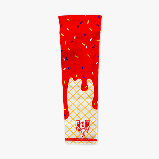 Ice cream arm sleeve laid flat on a white background featuring a red dripping frosting and rainbow sprinkle print over a waffle cone design with a BL101 logo near the wrist