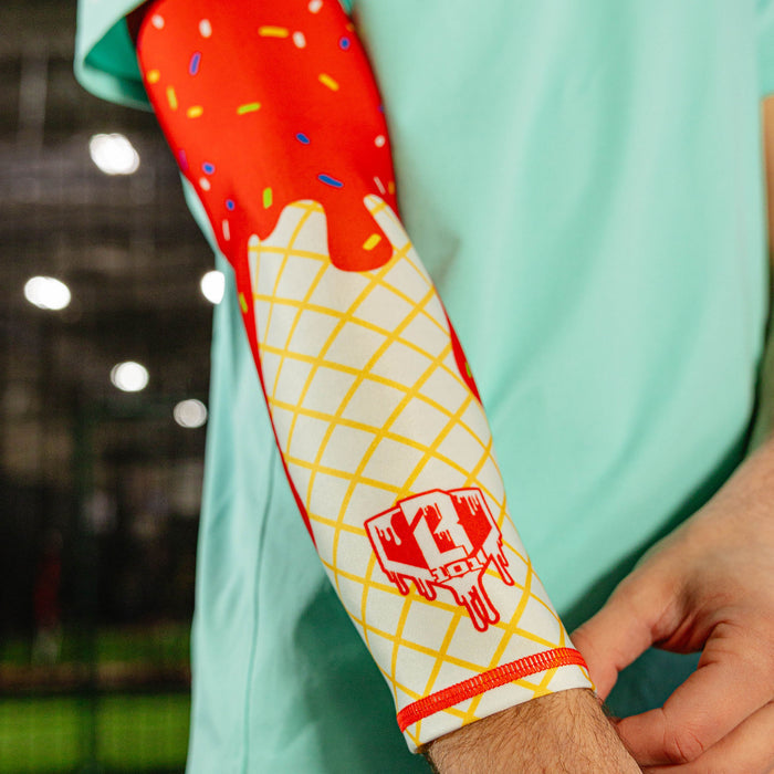 Close-up of the ice cream arm sleeve on a player's arm showing the red dripping frosting waffle cone print and BL101 logo near the wrist