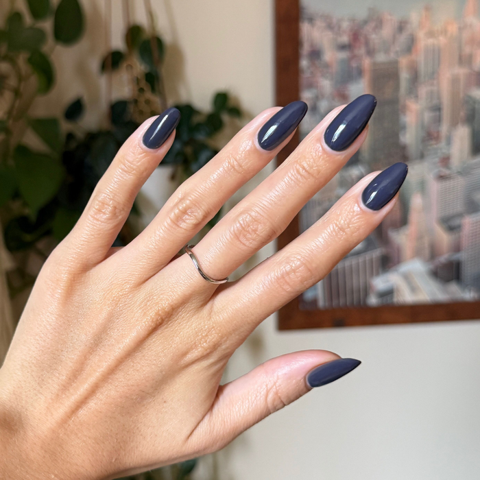 Hand with almond shaped nails painted in glossy Inkling gel polish showing a smooth quick dry manicure indoors