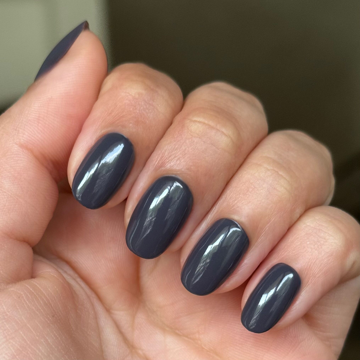 Hand with oval nails painted in glossy Inkling gel polish showing a smooth quick dry manicure indoors