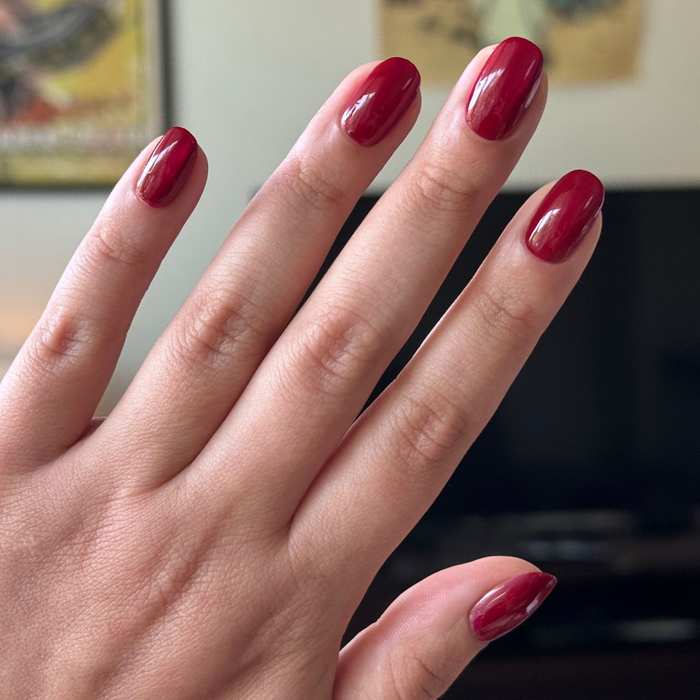 Jammy gel polish in vibrant cabernet shade on natural nails with smooth glossy finish in indoor setting