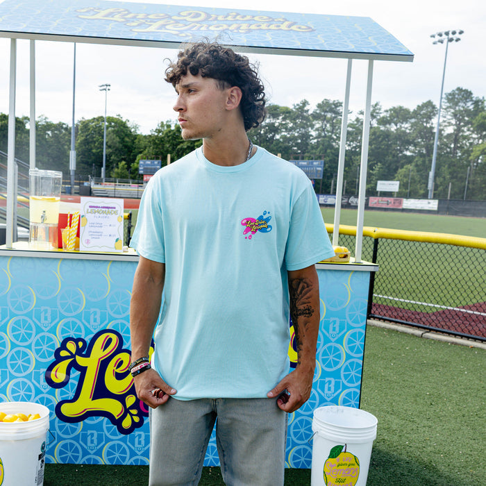 Adult model wearing blue graphic tee with "Lemon Burst" design