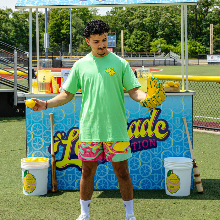 Adult model wearing green graphic tee with "Lemon Dingers" design