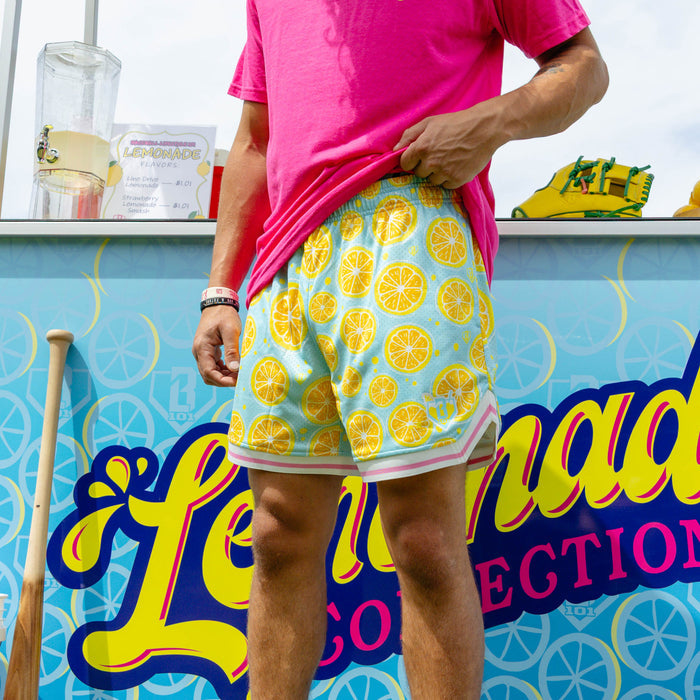 Adult model wearing blue shorts with "Lemon Squeeze Court" design