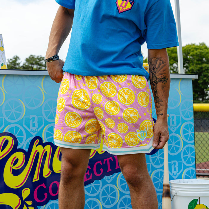 Adult model wearing pink shorts with "Lemon Squeeze Court" design