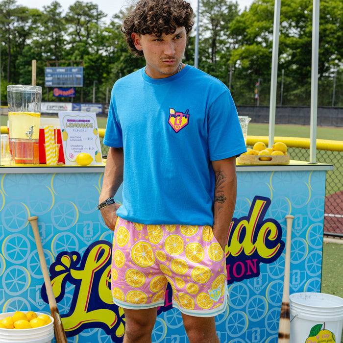 Adult model wearing pink shorts with "Lemon Squeeze Court" design