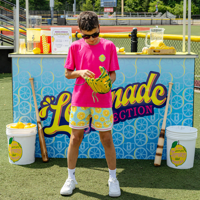 Youth model wearing blue youth shorts with "Lemon Squeeze Court" design
