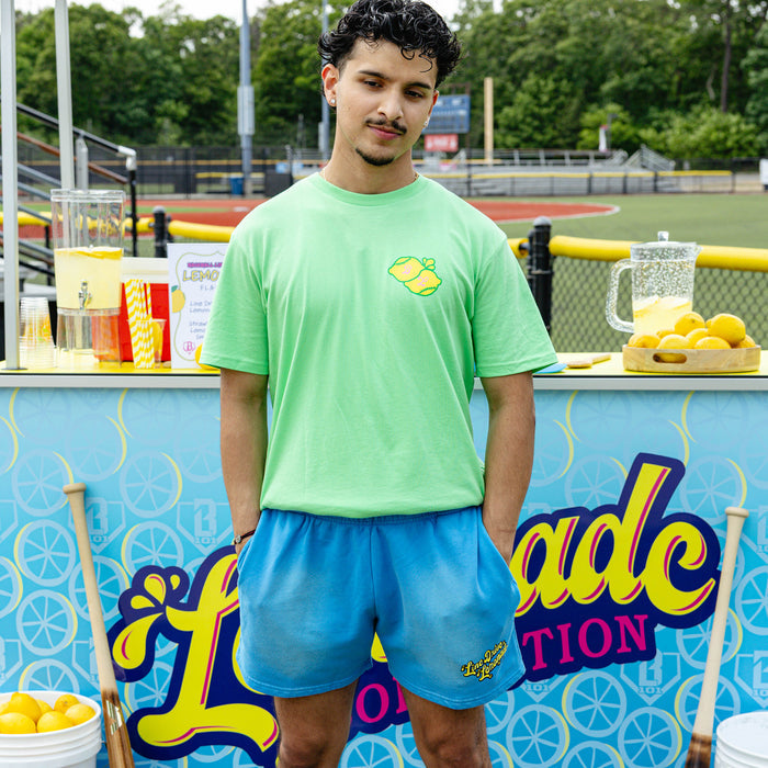Adult model wearing blue shorts with "Lemonade Cup" design