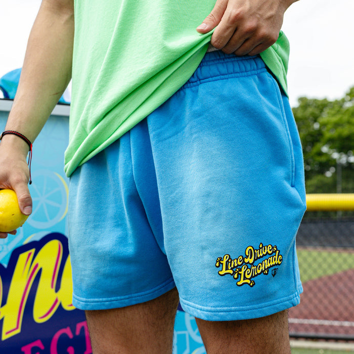 Adult model wearing blue shorts with "Lemonade Cup" design