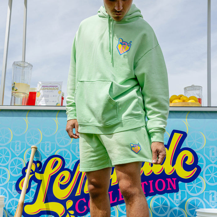 Adult model wearing green shorts with "Lemonade" design